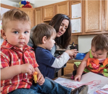 mother drawing with her three children